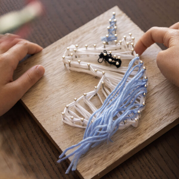 Child creates intricate string art Fostering focus creativity patience therapeutic skill development
